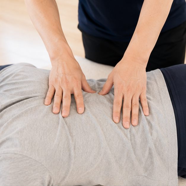 患者の腰にそっと手を添える院長の手元